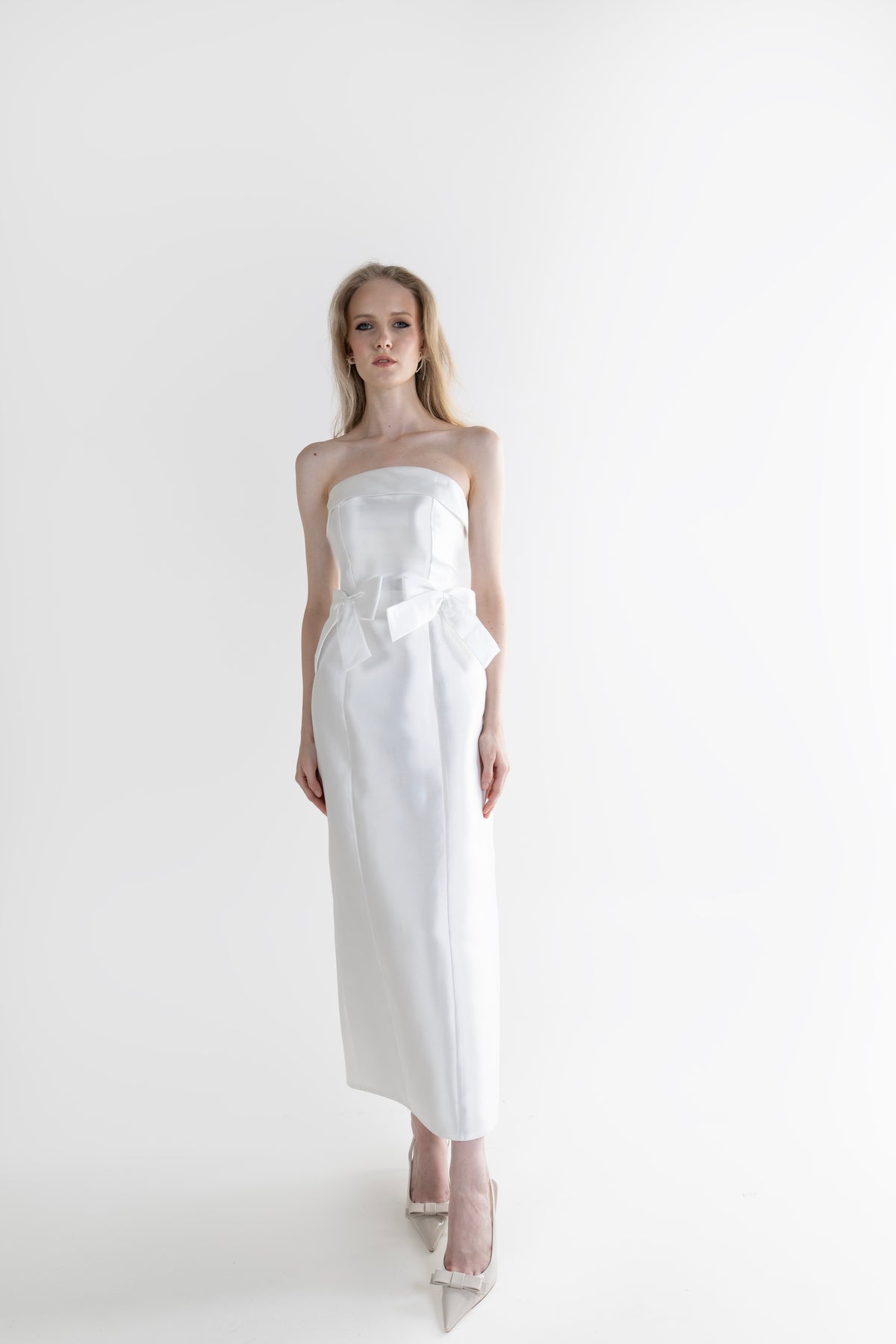 IRA by Irini Charalampous, @irathebrand online shop fashionable ready-to-wear womenswear brand CELIA strapless midi dress featuring bow appliqué detailing and tailored silhouette in white color. Shop online from Cyprus and Greece.