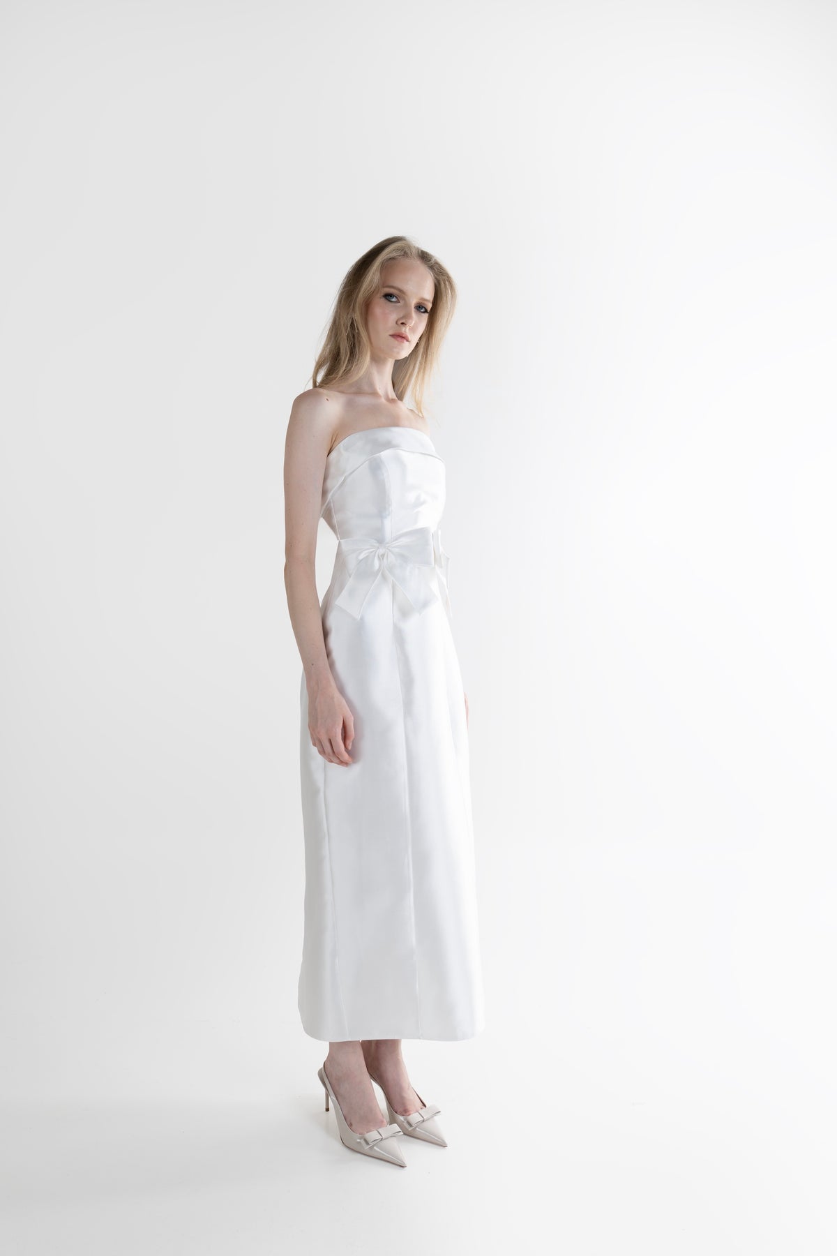 IRA by Irini Charalampous, @irathebrand online shop fashionable ready-to-wear womenswear brand CELIA strapless midi dress featuring bow appliqué detailing and tailored silhouette in white color. Shop online from Cyprus and Greece.