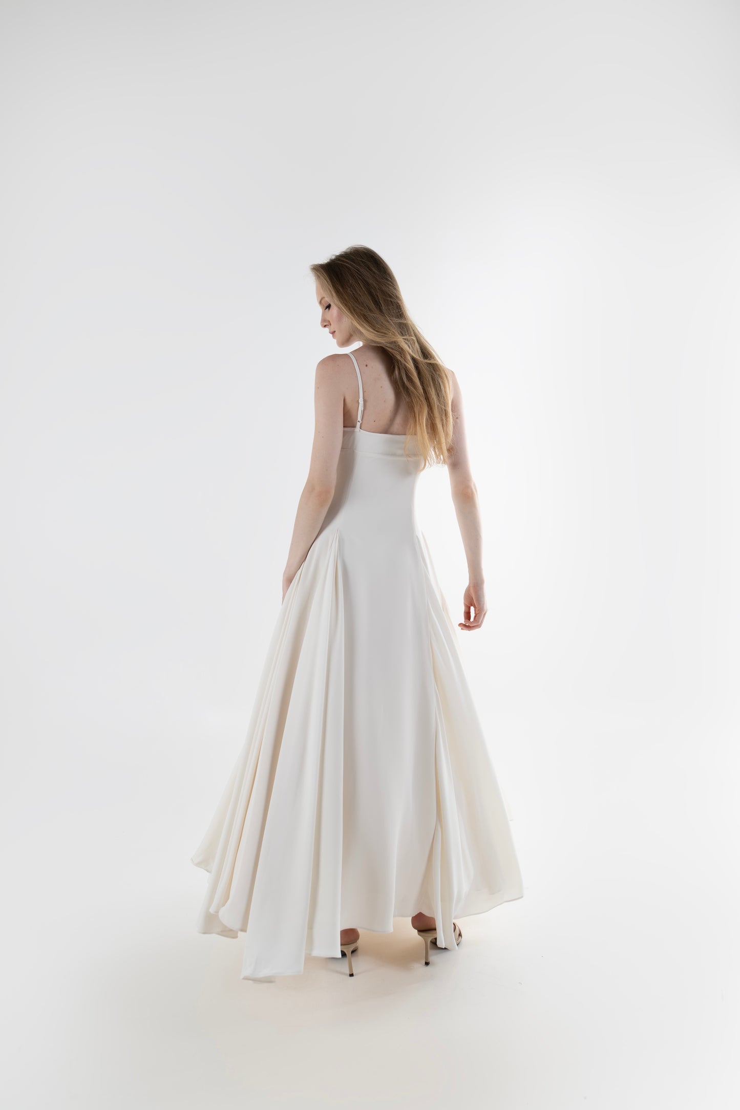 IRA by Irini Charalampous, @irathebrand online shop fashionable ready-to-wear womenswear brand SENA maxi gown with spaghetti straps flowing skirt and structured bodice in off white color. Shop online from Cyprus and Greece.
