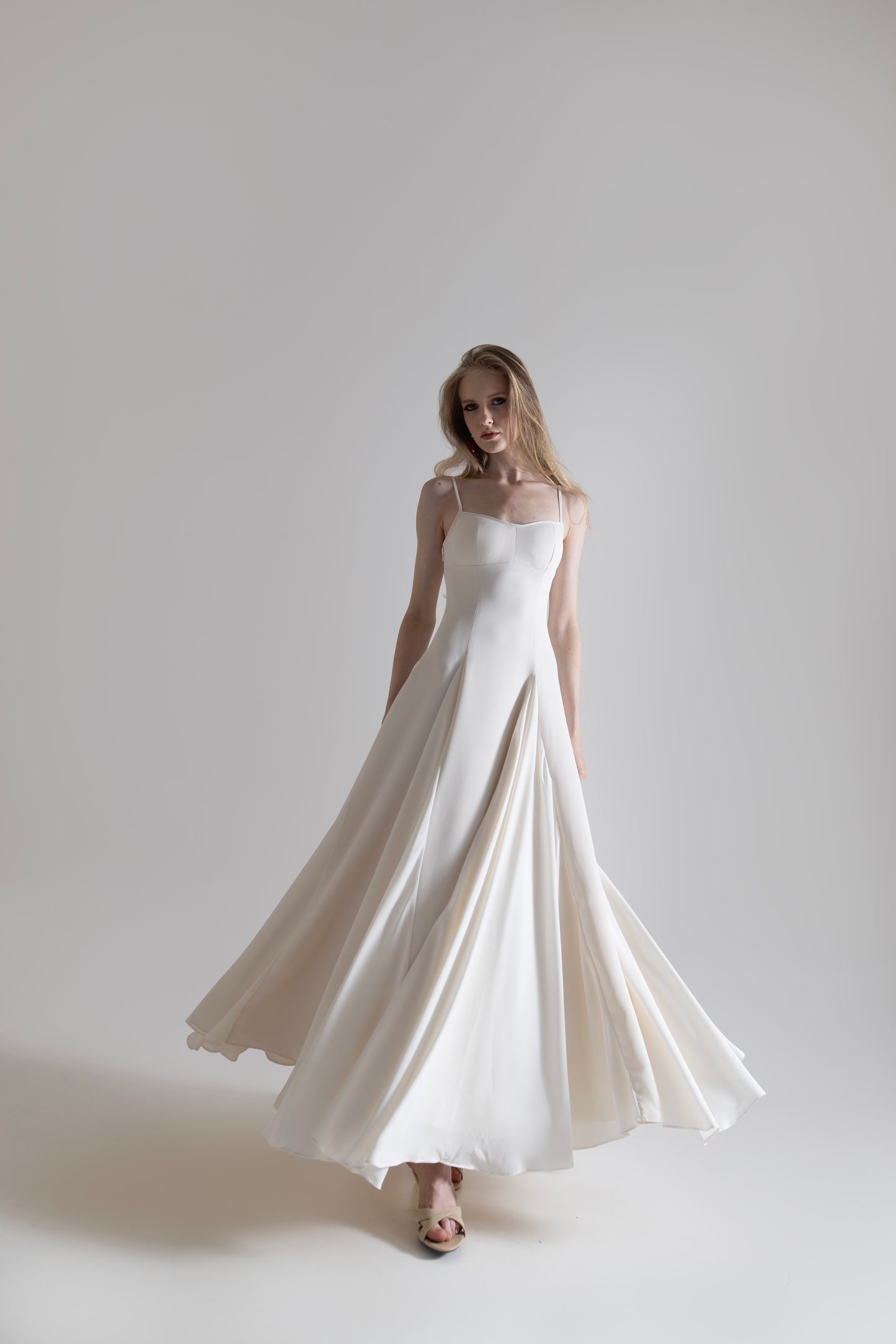 IRA by Irini Charalampous, @irathebrand online shop fashionable ready-to-wear womenswear brand SENA maxi gown with spaghetti straps flowing skirt and structured bodice in off white color. Shop online from Cyprus and Greece.