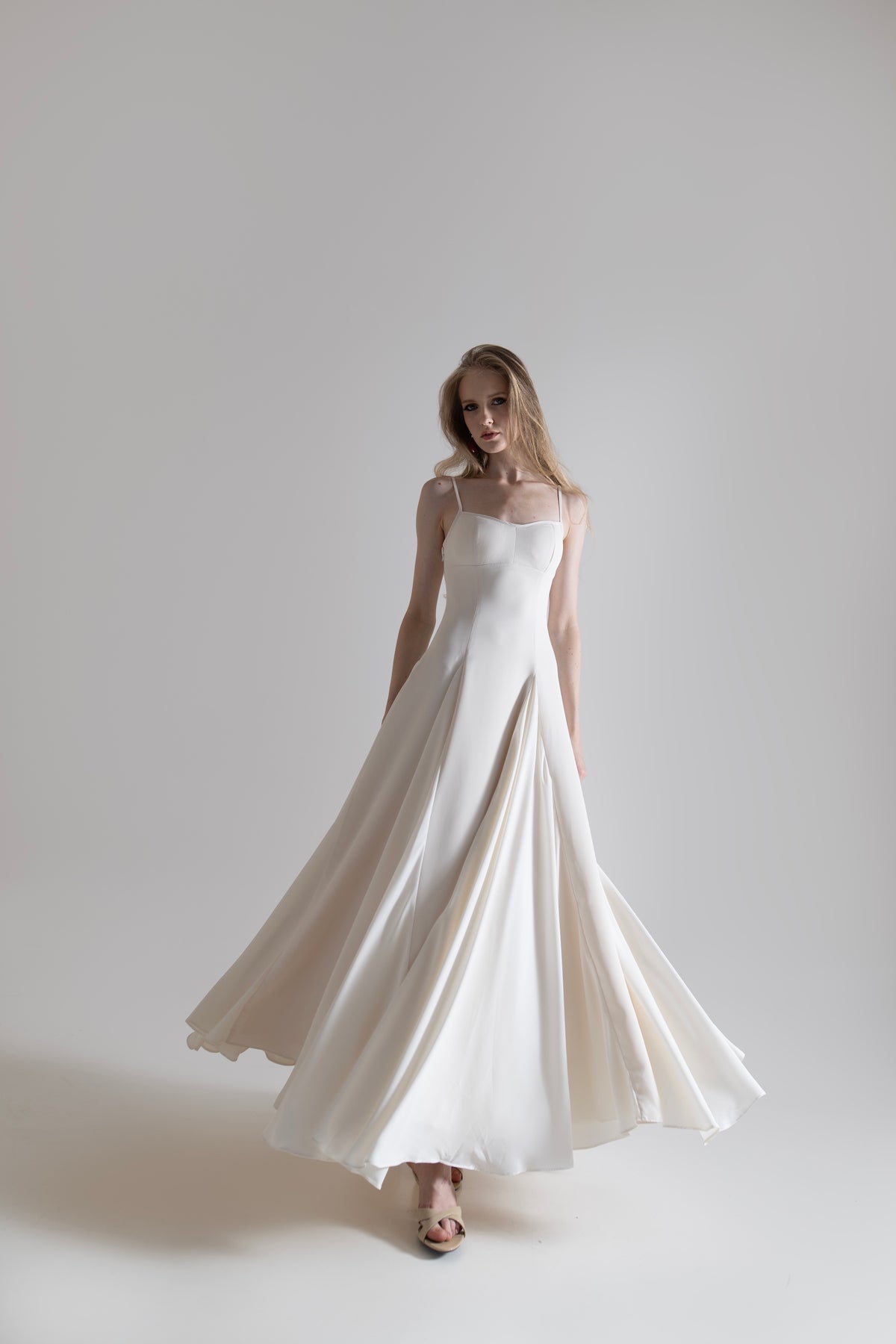 IRA by Irini Charalampous, @irathebrand online shop fashionable ready-to-wear womenswear brand SENA maxi gown with spaghetti straps flowing skirt and structured bodice in off white color. Shop online from Cyprus and Greece.