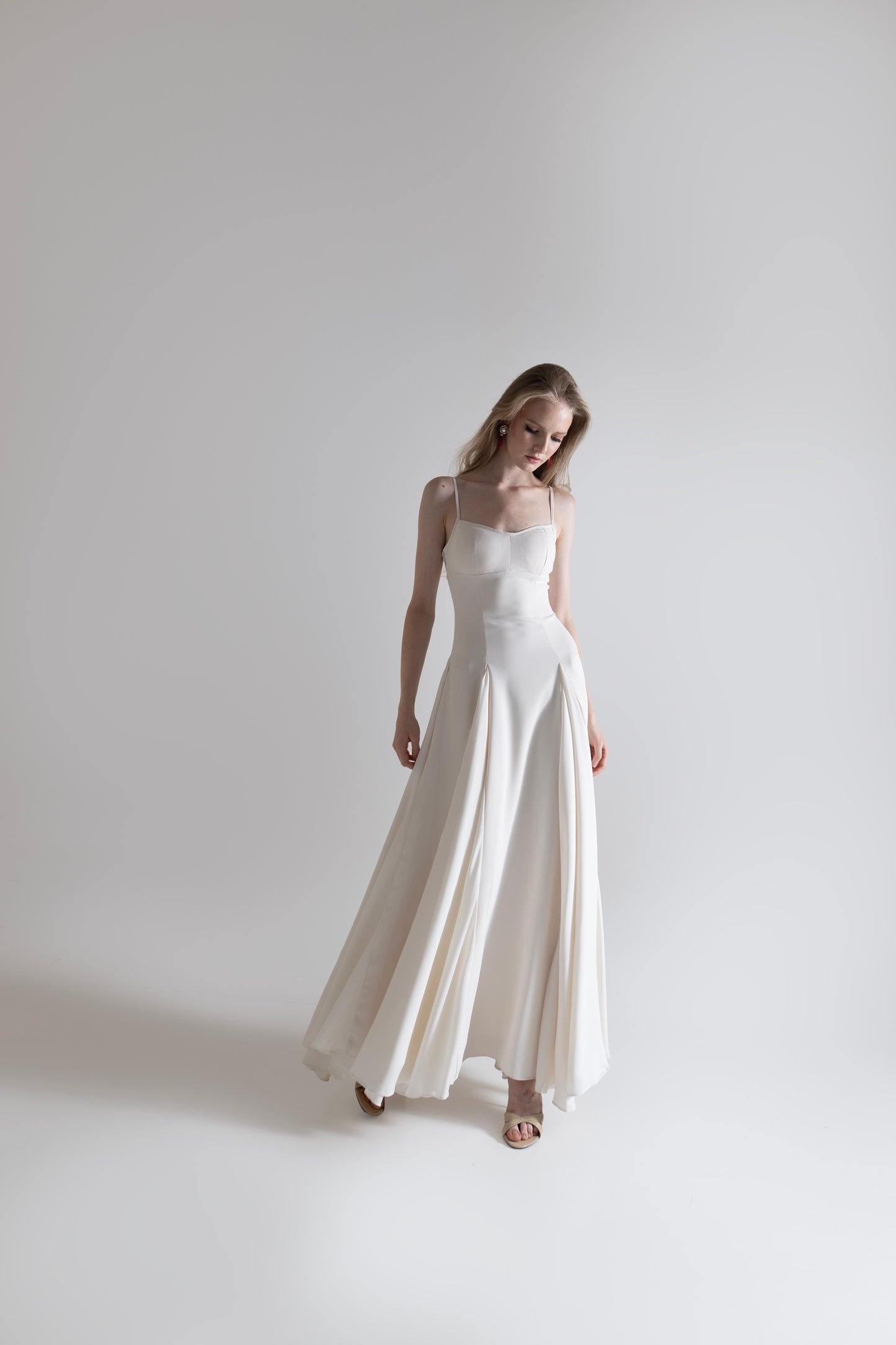 IRA by Irini Charalampous, @irathebrand online shop fashionable ready-to-wear womenswear brand SENA maxi gown with spaghetti straps flowing skirt and structured bodice in off white color. Shop online from Cyprus and Greece.