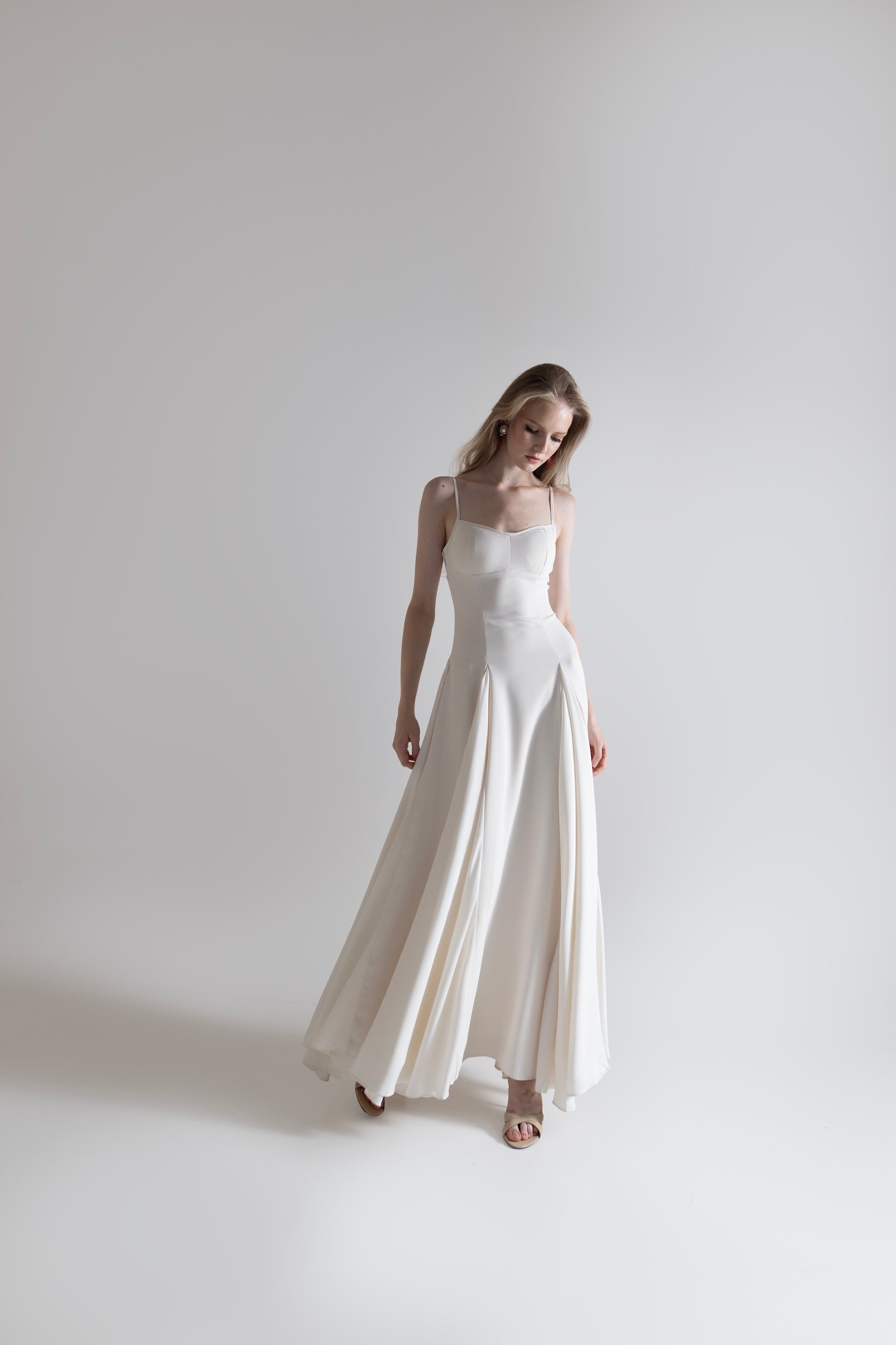 IRA by Irini Charalampous, @irathebrand online shop fashionable ready-to-wear womenswear brand SENA maxi gown with spaghetti straps flowing skirt and structured bodice in off white color. Shop online from Cyprus and Greece.