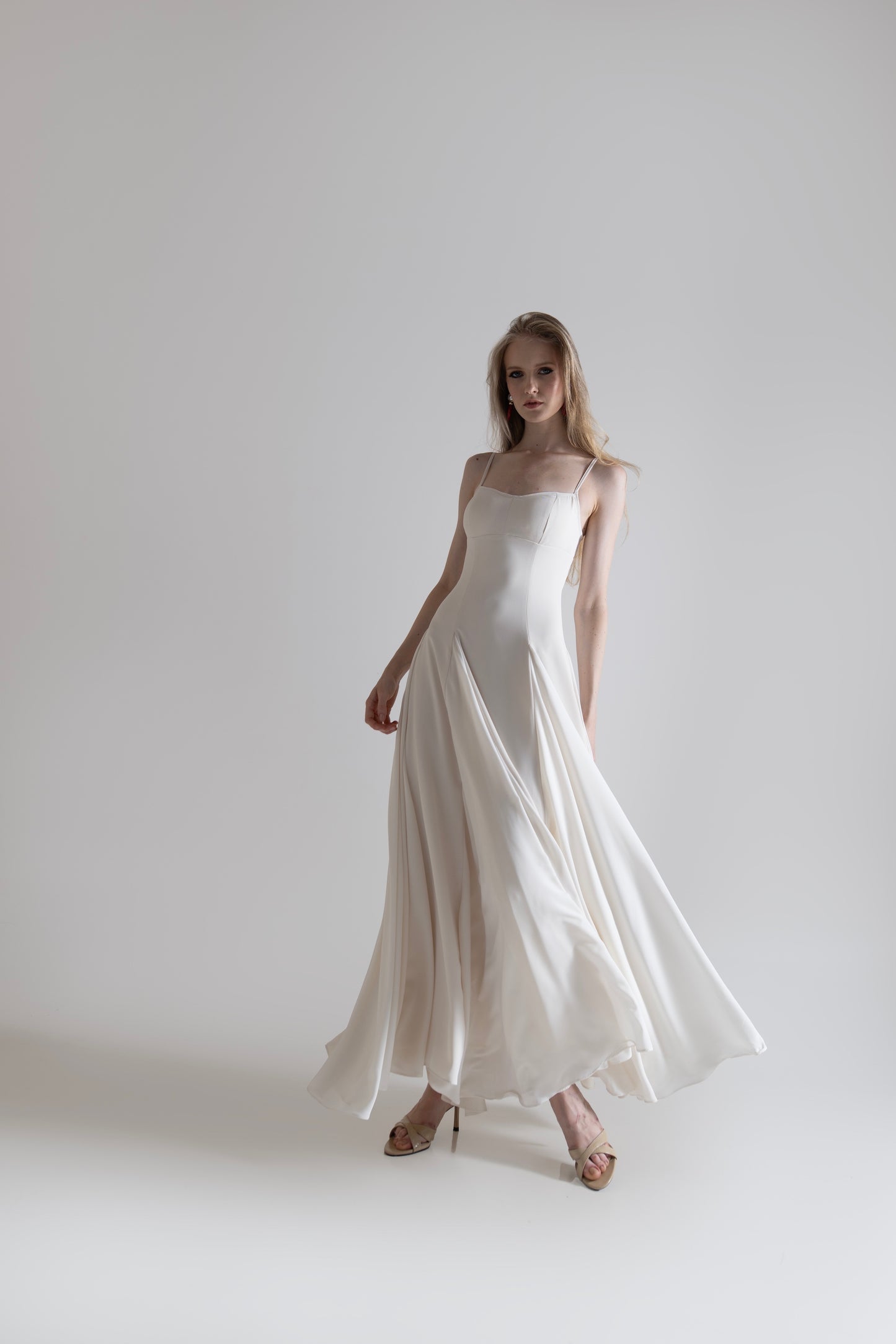 IRA by Irini Charalampous, @irathebrand online shop fashionable ready-to-wear womenswear brand SENA maxi gown with spaghetti straps flowing skirt and structured bodice in off white color. Shop online from Cyprus and Greece.